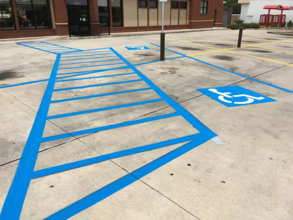 Blue accessible parking access aisle with hatch lines and symbol