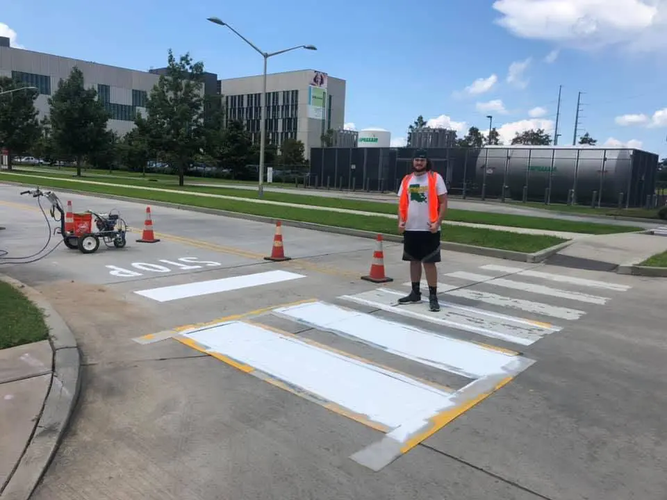 RPM crew member beside a freshly painted crosswalk and STOP bar