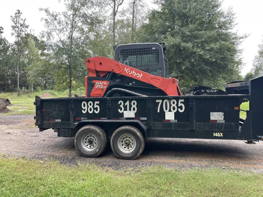 Dump trailer and track loader at a job site